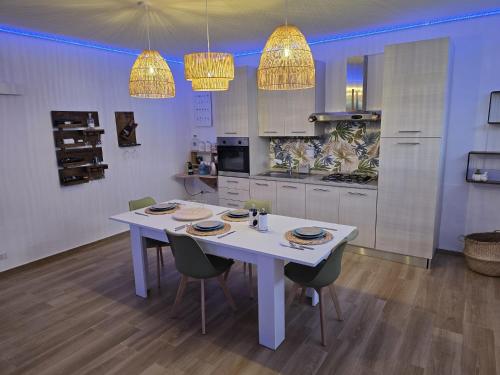 a kitchen with a white table and chairs and lights at Sea and Sand's Ville HOWME in Bari
