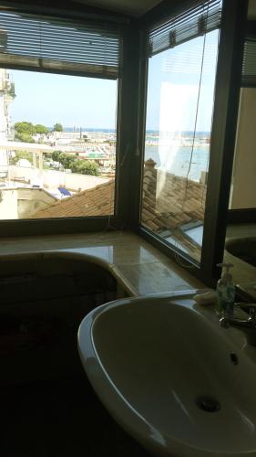 a bathroom with a sink and a view of the ocean at Rose Apartment in Crotone