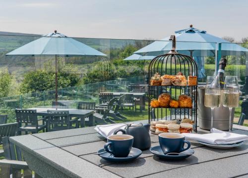 a table with a bird cage with pastries and cups of coffee at Hotel Victoria in Whitby