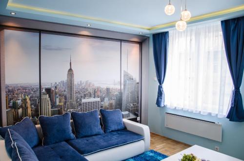 a living room with a blue couch and a large window at Blue Luxury Apartment in Budapest