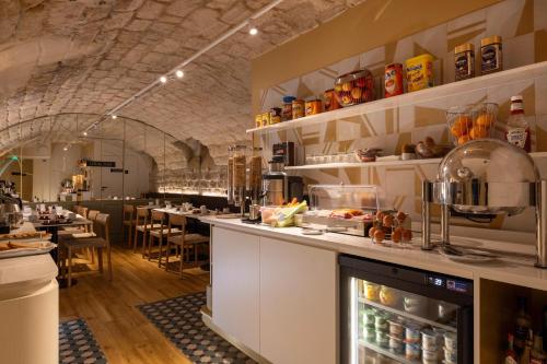 un restaurant avec un comptoir et un bar dans l'établissement Best Western Bretagne Montparnasse, à Paris