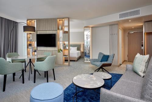 a living room with a couch and a table and chairs at Courtyard by Marriott Berlin City Center in Berlin