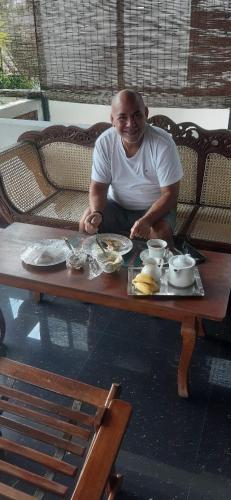 a man sitting at a table with a plate of food at Melvila in Colombo