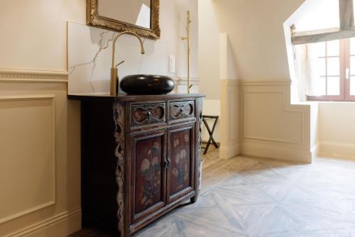 a room with a wooden cabinet with a bowl on top at Manoir de Laroque Delprat in Autoire