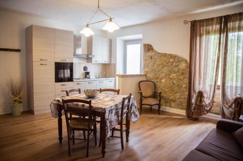 - une cuisine et une salle à manger avec une table et des chaises dans l'établissement Bio Agriturismo Poggio Aione, à Saturnia