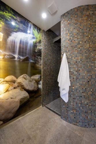 a bathroom with a waterfall mural on the wall at Domki Apartamentowe Bueno in Dąbki