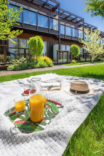 a picnic table with two glasses of orange juice at Domki Apartamentowe Bueno in Dąbki