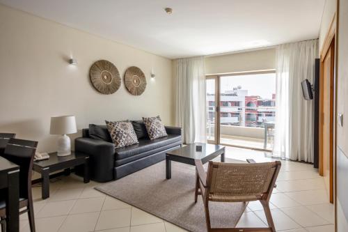 a living room with a couch and a table at Areias Village Beach Suite Hotel in Albufeira