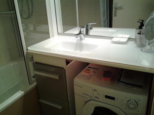 une salle de bain avec un lavabo et une machine à laver dans l'établissement Résidence Green Village, à La Grande Motte