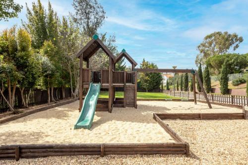 a playground with a slide in the sand at Areias Village Beach Suite Hotel in Albufeira