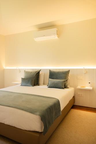 a bedroom with a large bed with blue pillows at Batalha Golf Villas & Spa in Ponta Delgada