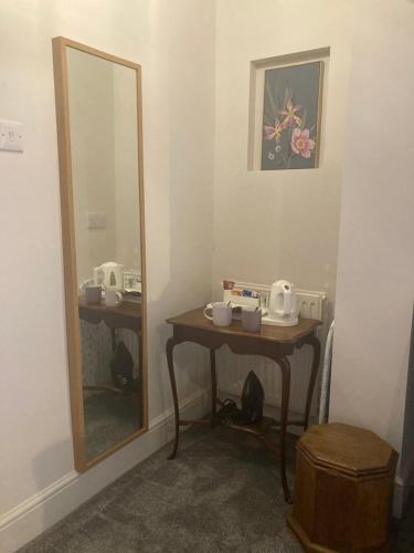 a bathroom with a mirror and a wooden table with a mirror at Crick Cottage Rooms in Crick