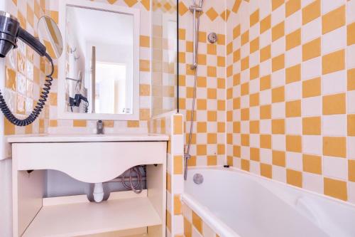 une salle de bain avec un lavabo, une baignoire et un miroir dans l'établissement Résidence Cannes Villa Francia - maeva Home - Appartement 2 pièces 5 personnes - Sélection MAE-9021, à Cannes