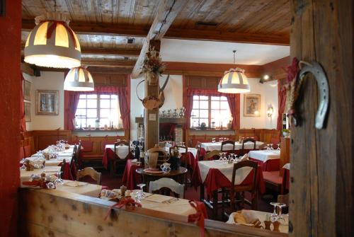 een eetkamer met tafels en stoelen in een restaurant bij Affittacamere Lou Ressignon in Cogne