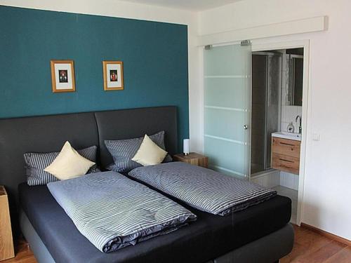 1 cama en un dormitorio con una pared azul en Ferienwohnung Lydia, en Zell am Harmersbach