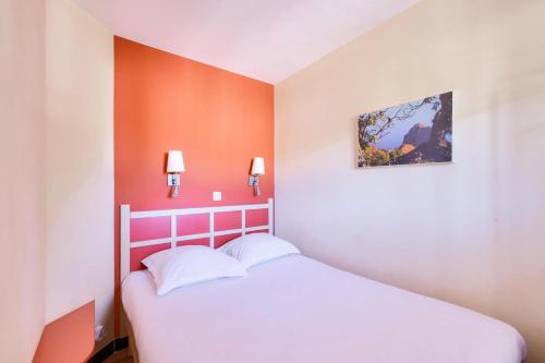 une chambre avec un lit blanc avec un mur orange dans l'établissement Résidence Cannes Villa Francia - maeva Home - Appartement 2 pièces 4 personnes - Sélection MAE-2351, à Cannes