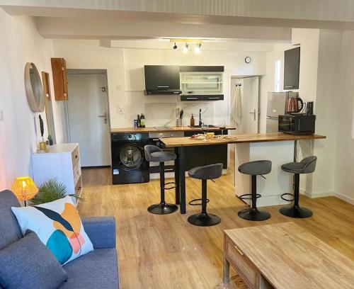 - un salon avec une cuisine dotée d'un comptoir et de tabourets dans l'établissement Nid perché en centre historique d'Avignon, à Avignon