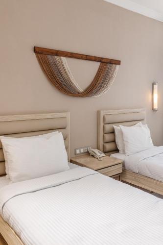 a bedroom with two beds and a mirror on the wall at Fun & Sun Club Saphire in Tekirova