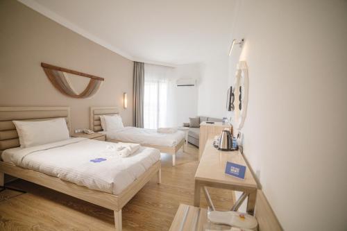 a hotel room with two beds and a table at Fun & Sun Club Saphire in Tekirova