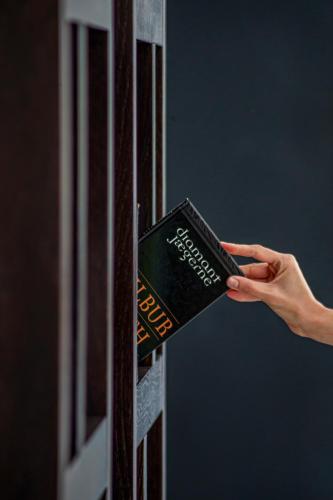 a person is holding a book on a wall at Areias Village Beach Suite Hotel in Albufeira