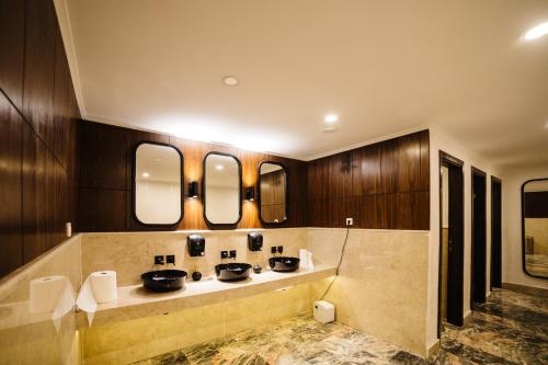 a bathroom with two sinks and three mirrors at Fun & Sun Club Saphire in Tekirova