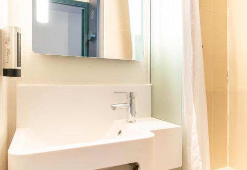 ein Badezimmer mit einem weißen Waschbecken und einem Spiegel in der Unterkunft B&B HOTEL Nantes Centre in Nantes