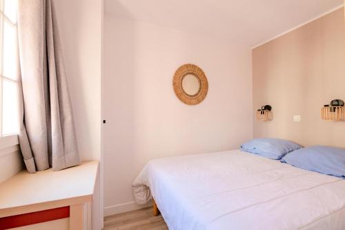 une chambre avec un lit et un miroir au mur dans l'établissement Résidence le Village de Cap Esterel - maeva Home - Appartement cosy 2 pièces 4 personnes - Prestige - super Home MAE-2121, à Saint-Raphaël