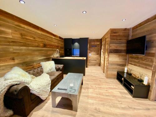 un salon avec un canapé et une table dans l'établissement appartement sur les pistes, lumineux et central Courchevel 1850, à Courchevel