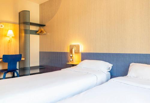 two beds sitting next to each other in a room at B&B HOTEL Nantes Centre in Nantes