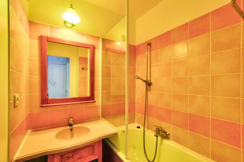 une salle de bain avec un lavabo, une baignoire et un miroir dans l'établissement La résidence du Lac - maeva Home - Appartement 2 pièces 5 personnes - Sélection MAE-6761, à Monflanquin