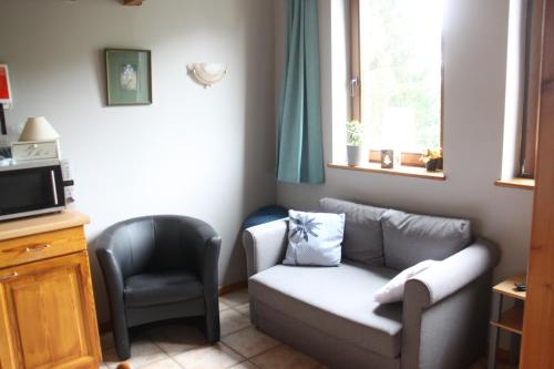 a living room with a couch and a chair at B&B La Grange in Durbuy