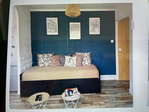 Schlafzimmer mit einem Bett mit blauer Wand in der Unterkunft Maison lumineuse, proche centre. in Châteauroux
