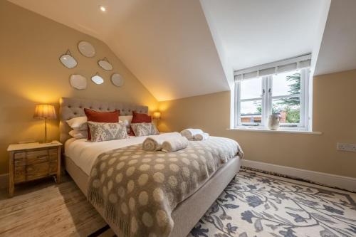 a bedroom with a large bed and a window at Charnwood Cottage 4 in Burnham Market