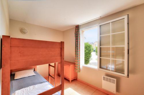 une chambre avec un lit superposé et une fenêtre dans l'établissement La résidence du Lac - maeva Home - Studio 5 personnes - Sélection MAE-6771, à Monflanquin