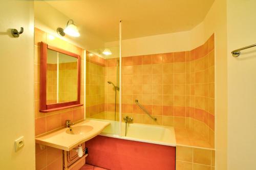 une salle de bain avec un lavabo et une baignoire dans l'établissement La résidence du Lac - maeva Home - Studio 5 personnes - Sélection MAE-6771, à Monflanquin