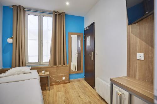 a small room with a bed and a mirror at Merryl Hotel in Paris