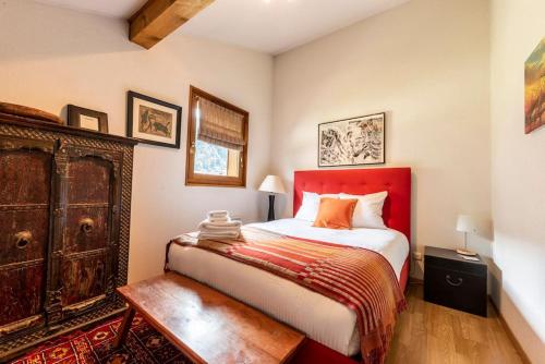 - une chambre avec un lit rouge et une armoire en bois dans l'établissement Morzine Apartment, à Morzine
