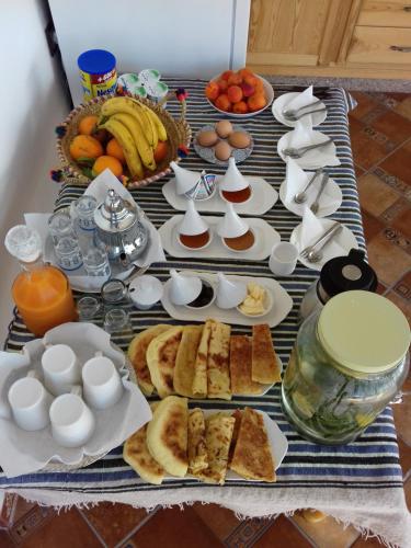 a table topped with plates of food and fruit at Dar El Hayet in Tangier