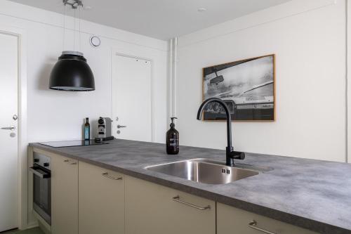 a kitchen with a sink and a black lamp at Kings Square apartments by Daniel&Jacob's in Copenhagen