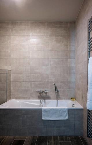 une baignoire avec un robinet dans une salle de bain dans l'établissement Apartment Sycamore, aux Gets