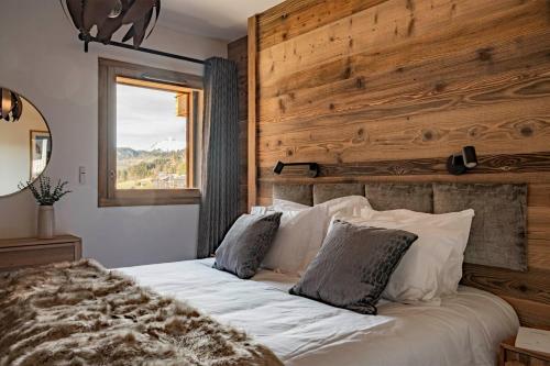 - une chambre avec un grand lit blanc et un mur en bois dans l'établissement Apartment Sycamore, aux Gets