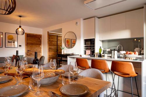 une cuisine avec une table en bois et des chaises et une cuisine avec un comptoir dans l'établissement Apartment Sycamore, aux Gets