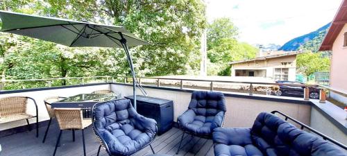 uma varanda com uma mesa e cadeiras e um guarda-sol em Black&White Home-by So'SerenityHome-Balcon-Parking em Cluses