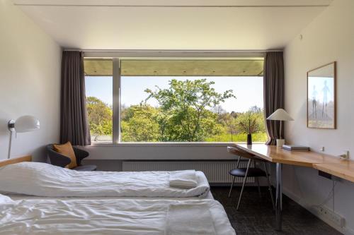 埃伯爾措夫特的住宿－Toppen af Ebeltoft，一间卧室配有一张床、一张书桌和一个窗户。