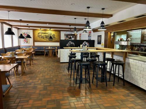 un restaurant avec des tables et des chaises ainsi qu'un bar dans l'établissement Brauereigasthof Bären, à Titisee-Neustadt