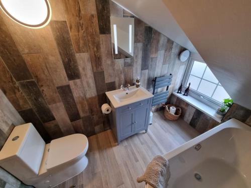 a bathroom with a sink and a toilet and a tub at Trinket - The Cliff Top Cottage in Sewerby