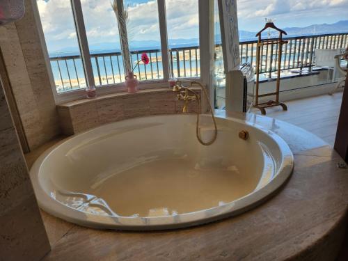 萊斯卡拉的住宿－Solo Atico Guest Suites，带浴缸的浴室,享有海景。