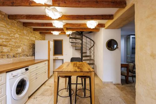 une cuisine avec une table en bois et un escalier en colimaçon dans l'établissement La Bastide Spirale - Welkeys, à Avignon