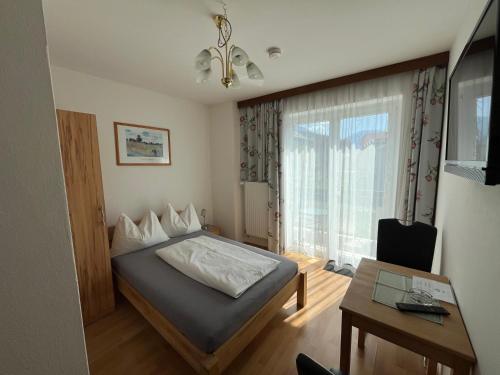 1 dormitorio con cama, mesa y ventana en Seemüllnerhaus, en Millstatt