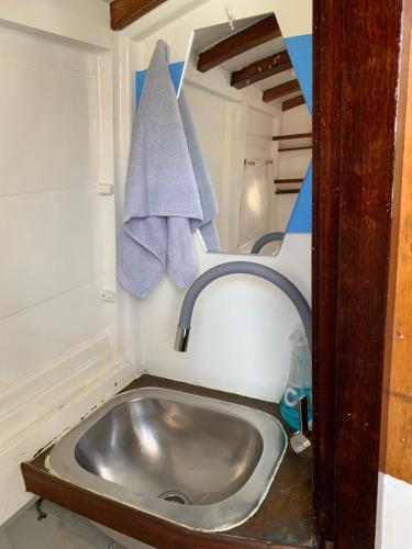 a bathroom sink with a towel hanging over it at Lovely wooden boat in Port forum, with AC and two bikes. in Barcelona
